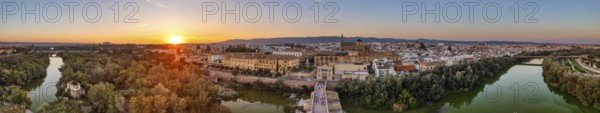 Panoramic view of a city at sunset with river and bridge in the foreground, Cordoba