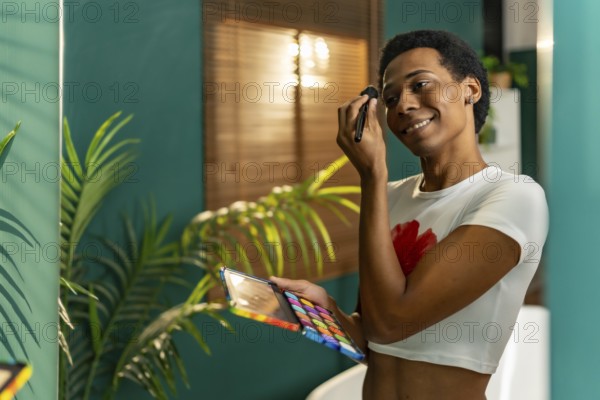 Reflection in the mirror of a happy gay man making up at home