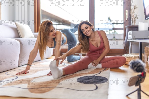 Two friends engaged in an online yoga class, practicing stretching and meditation in a cozy living room setting, promoting wellness and relaxation
