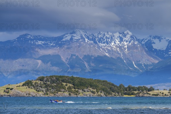 Motorboat with tourists travelling fast on the lake Lago General Carrera, also Lago Chelenko, snow-covered mountains behind, Puerto Rio Tranquilo, Aysen region, Patagonia, Chile, South America