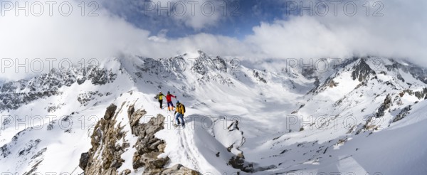 Three mountaineers climbing the narrow ridge of Piz Laviner, view of mountain panorama in winter mountain landscape, Grisons Haute Route, Albula Alps, Rhaetian Alps, Grisons, Eastern Switzerland, Switzerland, Europe