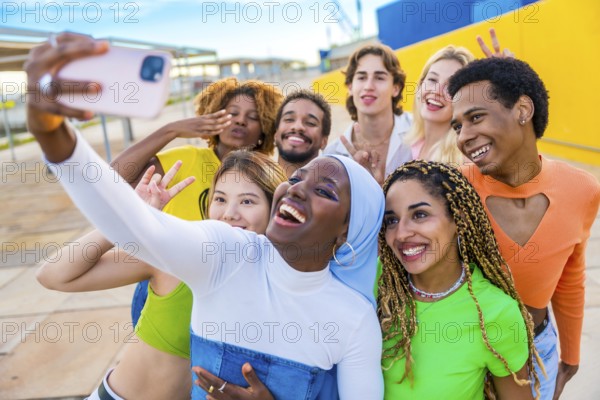 Cheerful muslim african woman taking a selfie with friends in an urban space