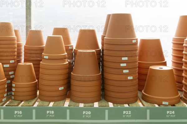 Variety of sizes of clay flower pots on display in at Swanns Nursery garden centre, Suffolk, England, UK