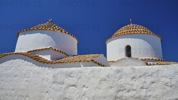 Two white painted church towers with red tiled roofs and small windows, bright blue sky, Chora, Old Town, Patmos, Dodecanese, Greek Islands, Greece, Europe
