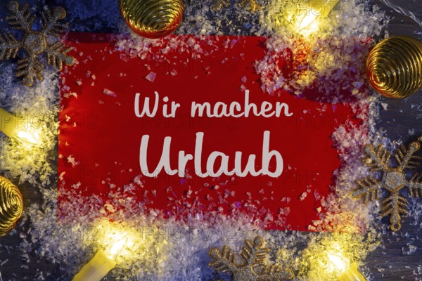 Sign with the inscription WIR MACHEN URLAUB with Christmas decorations