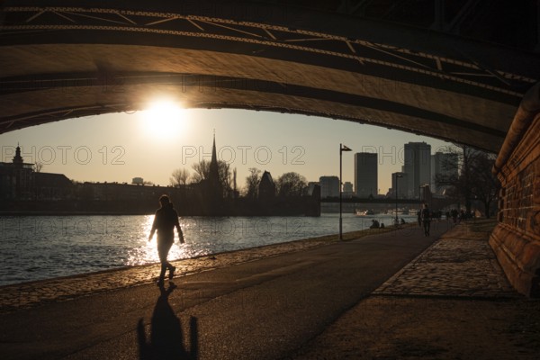 Passers-by walking along the banks of the Main at sunset in Frankfurt, Frankfurt am Main, Hesse, Germany, Europe