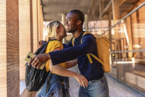 Multiracial students smiling happily while embracing and greeting at the university campus