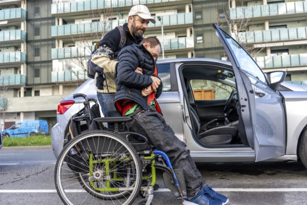 Man assisting disabled friend in getting out of a car parked on an urban street, showcasing the importance of friendship and support