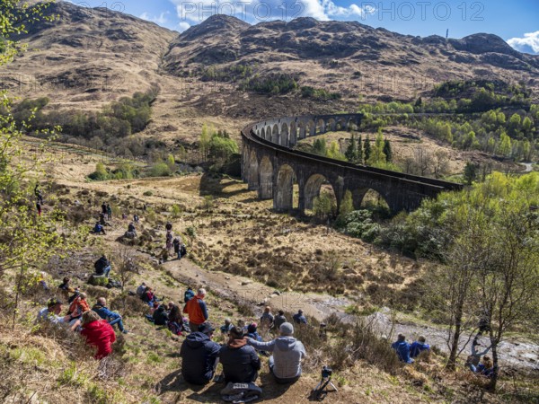 Tourists waiting for the jacobite steam train at the Glenfinnan viaduct, scottish highland, Scotland, UK