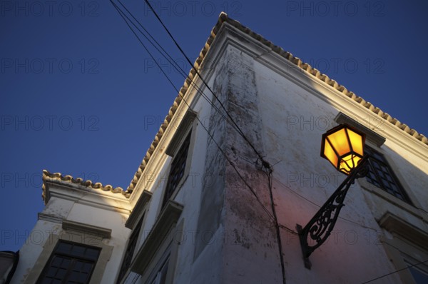 Lantern, street lamp, shines on house wall, old town, Faro, dusk, evening light, Algarve, Portugal, Europe