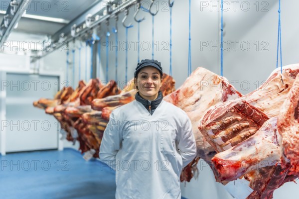 Caucasian adult female manual worker standing proud in a meat processing factory