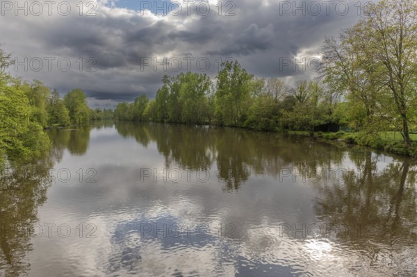 Stormy weather over a tree-lined natural river in spring. L'ill, Hutenheim, Bas Rhin, Alsace, France, Europe