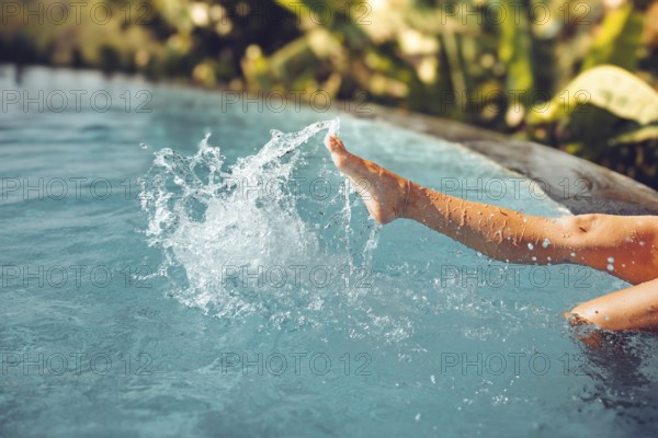 Beautiful female legs splashing in the pool, Bali, Indonesia, Asia