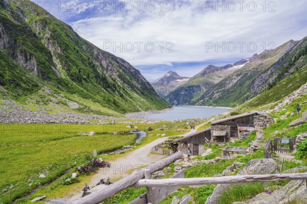 View of a mountain landscape with a lake, huts and a path through a green meadow, Klein Tibet, Zillertal, Austria, Europe