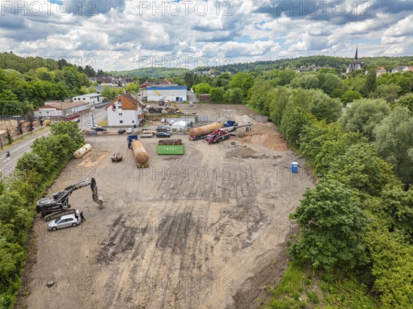 Landscape view of a large construction site in the countryside, surrounded by houses and a cloudy sky, demolition site of a former lorry transport company with oil tanks, Saarbrücken, Germany, Europe