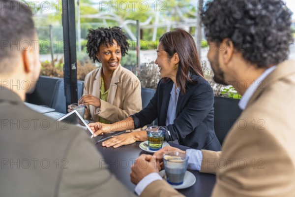 Business people using digital tablet during a meeting in a modern cafeteria