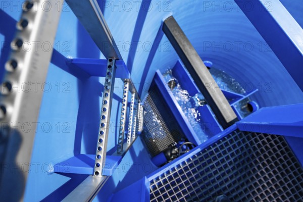 View into a blue tank with flowing water and several metal ladders, ENCW Netze Calw waterworks, Calw, Black Forest, Germany, Europe