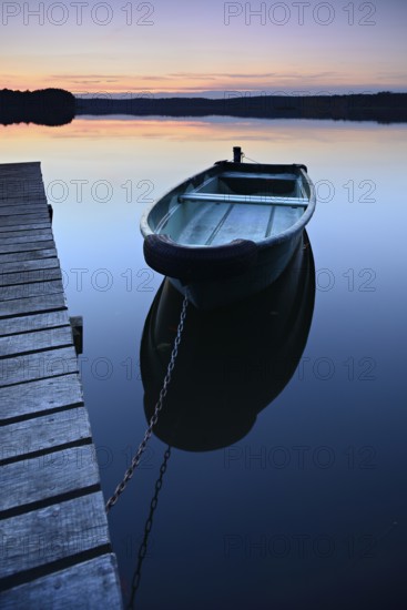 Quiet lake with jetty and rowing boat after sunset at dusk, Großer Lychensee, Lychen, Brandenburg, Germany, Europe