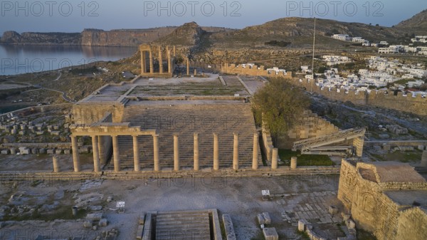 Drone shot, first morning light, Lindos, Acropolis of Lindos, Propylaea with staircase, Temple of Athena Lindia, The columns of an ancient temple, in the background mountains and blue twilight, Archaeological site, Lindos, Rhodes, Dodecanese, Greek Islands, Greece, Europe