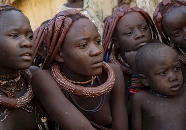 Group of Himba children and young woman look at pictures on a camera, near Opuwo, Kaokoveld, Kunene, Namibia, Africa