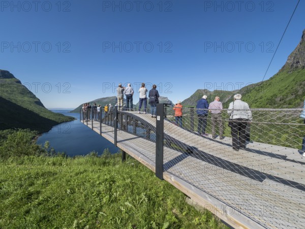 Tourist group visits viewing platform at Bergsbotn, viewpoint over fjord Bergsfjorden, Senja island, Norway, Europe