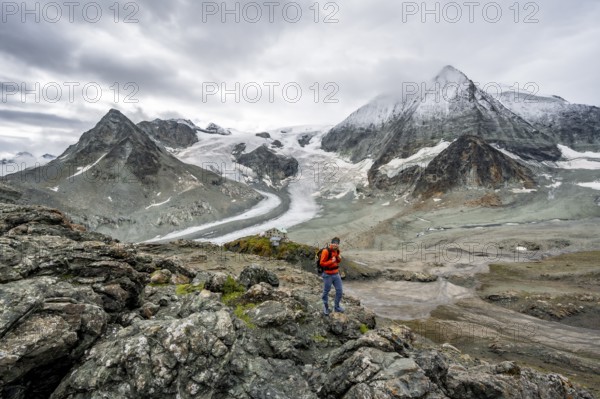 Mountaineer in front of impressive mountain landscape, mountain hut Cabane des Dix in front of glacier Glacier de Cheilon and summit Mont Blanc de Cheilon, Valais Alps, Valais, Switzerland, Europe