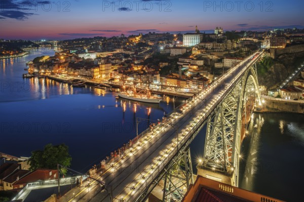 View of illuminated Porto city and Douro river and Dom Luis bridge I from famous tourist viewpoint Miradouro da Serra do Pilar in evening twilight. Porto, Vila Nova de Gaia, Portugal, Europe