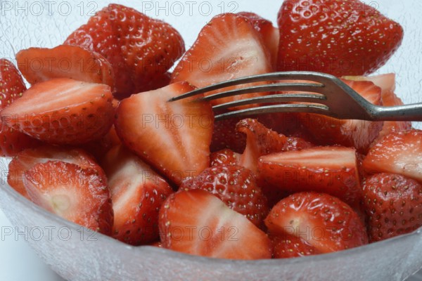Halved strawberries in a bowl, Fragaria
