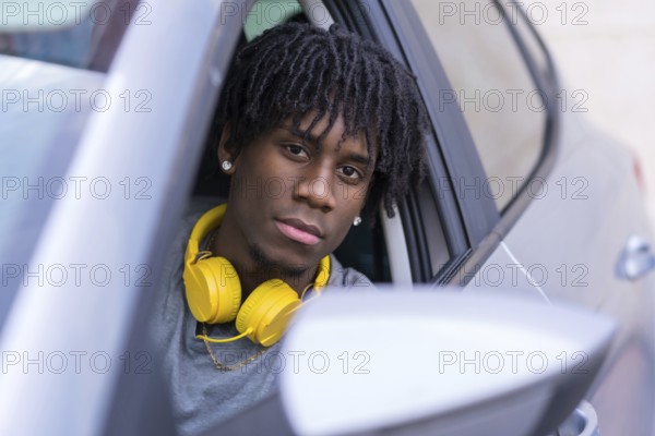 Close-up portrait of a serious african young man inside a car