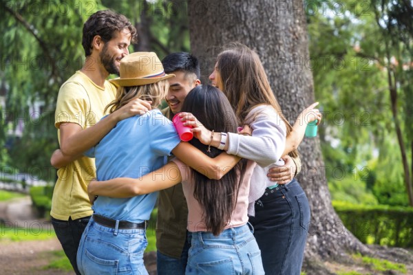 Multiethnic group of birthday party in the city park embraced in a symbol of friendship forever