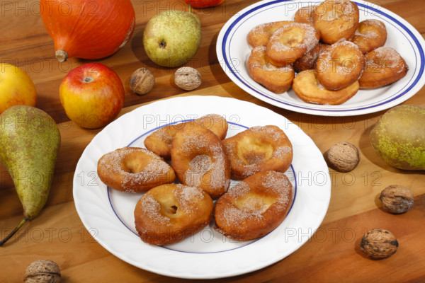 Swabian cuisine, harvest cakes, dessert, dessert, fat baked goods, doughnuts, fried food, lard noodles, arranged on a plate, grandmother's kitchen, regional, home cooking, typical Swabian, classic recipe, traditional cuisine, food photography, autumn atmosphere, apples, pears, nuts, still life, studio, Germany, Europe