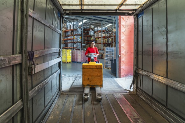 Views from inside the vehicle of a latin worker at a distribution warehouse loading boxes on a truck