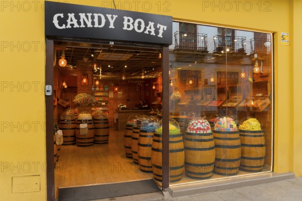 Confectionery shop with wooden barrels full of sweets and a yellow façade presenting a tempting variety of sweets, Ronda, Malaga, Andalusia, Spain, Europe