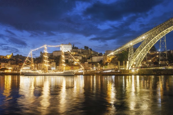 View of Porto city and Douro river with sailing ship from famous tourist viewpoint Marginal de Gaia riverfront in the evening. Porto, Vila Nova de Gaia, Portugal, Europe