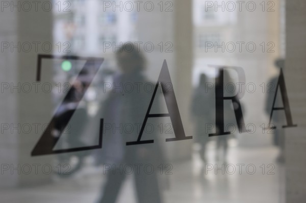 Company logo of the textile retail chain Zara, passers-by reflected in the shop window in Berlin, 27/03/2024