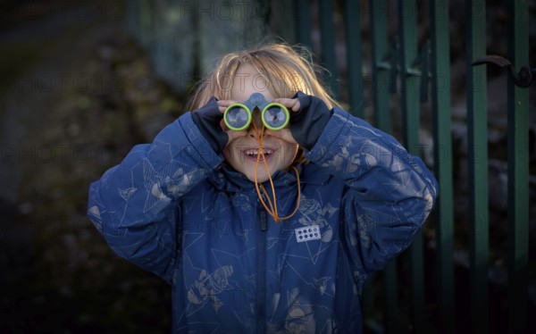 Little boy, 5 years, blond, looks through children's binoculars, toy, Stuttgart, Baden-Württemberg, Germany, Europe
