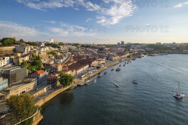 View of Vila Nova de Gaia city and Douro river with tourist boats on sunset. Porto, Portugal, Europe