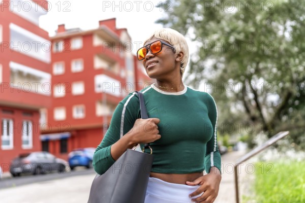 Cool african blonde woman smiling wearing casual clothes and sunglasses in the street
