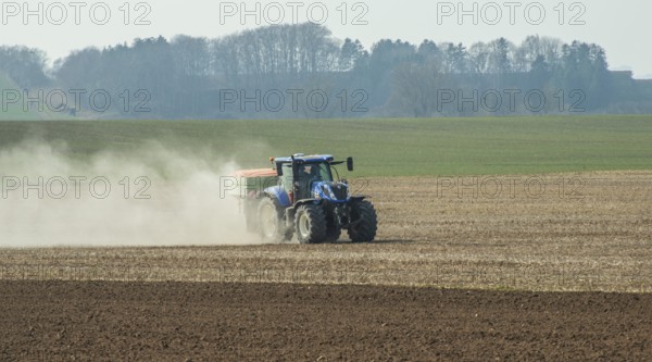 Spring farming, spreading fertilizer with tractor on field in Ystad municipality, Skåne county, Sweden, Scandinavia, Europe