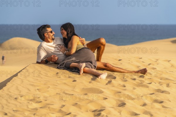 Tourists enjoying summer holidays lying on the sand in the maspalomas dunes, gran canaria, canary islands, spain