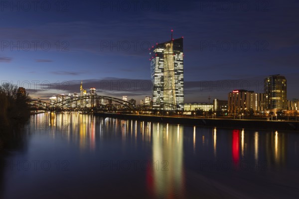 The lights in the offices of the European Central Bank (ECB) and in the skyscrapers of Frankfurt's banking skyline glow in the evening, Frankfurt am Main, Osthafen, Hesse, Germany, Europe