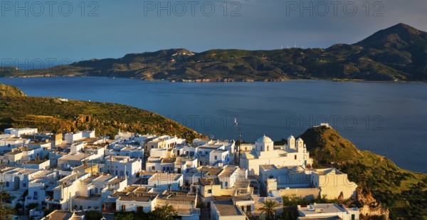 View of Plaka village on Milos island with traditional greek white houses on sunset. Plaka town, Milos island, Greece, Europe