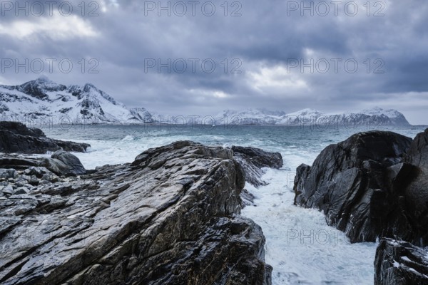 Waves of Norwegian sea crushing at rocky coast in fjord. Vikten, Lofoten islands, Norway, Europe