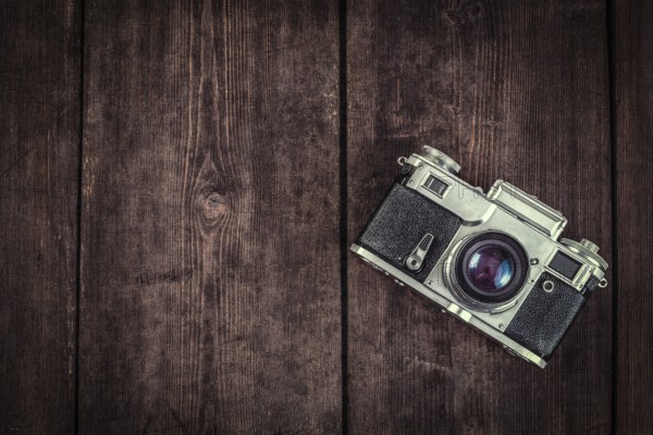 Photography concept background, old retro vintage camera on grunge wooden texture