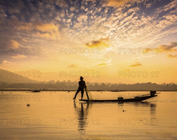 Myanmar travel attraction landmark, traditional Burmese fisherman sihouettes at Inle lake on sunset, Myanmar famous for their distinctive one legged rowing style