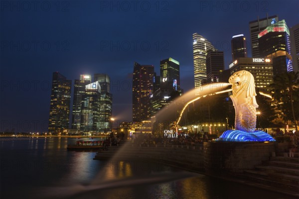 SINGAPORE, JANUARY 1, 2014: Night view of Singapore Merlion at Marina Bay against Singapore skyline. Merlion is a well-known tourist icon, mascot and national personification of Singapore
