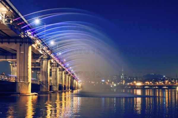 SEOUL, SOUTH KOREA, APRIL 7, 2017: Banpo Bridge Rainbow Fountain tourist landmark on Han river illuminated at night, Seoul, South Korea, Asia