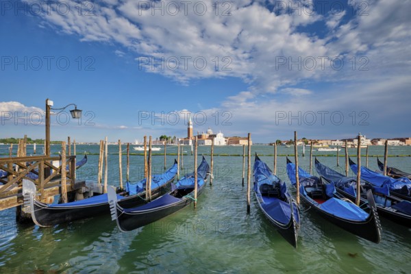 Gondolas and in lagoon of Venice by Saint Mark (San Marco) square with San Giorgio di Maggiore church in background in Venice, Italy, Europe