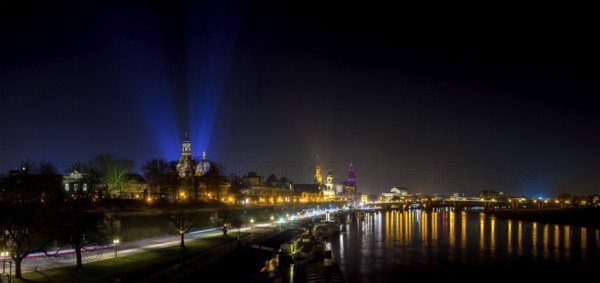 Dresden Silhouette View of the Old Town from the Carola Bridge. On the occasion of the commemoration of the 70th anniversary of the destruction of Dresden, floodlights shine into the night sky at the Church of Our Lady