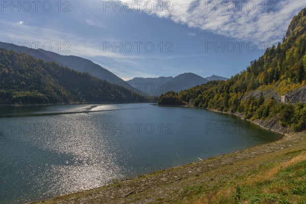 Intake structure at the Sylvenstein reservoir serves as flood protection, dams the Isar, power station, power generation, forest, driftwood on the bank, blue sky